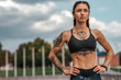 © byswat - Woman sports coach, summer city, fitness workout. Motivation strength mind thoughts. Tattoo cats on figure. Smart bracelet, watch. Free space. Beautiful girl in morning on the run.