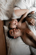 © Vadym - Young couple in hotel. Family waking up in the morning on bed. Cute couple waking up after a night sleep. Happy couple flirting and speaking in the morning on a comfortable bed at home. Relaxing after