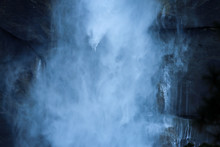 Misty Blue Waterfall In Yosemite With A Cliff In The Background