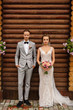 © Wedding photography - Wedding couple. Elegant bride and groom looking to camera. Portrait of beautiful newlywed couple on wooden background. Rustic wedding concept