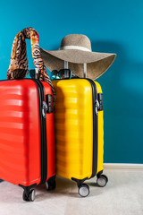 Bright and stylish cabin size suitcases and accessories as holiday concept agains dark blue background, copy space. Easy travel with little baggage