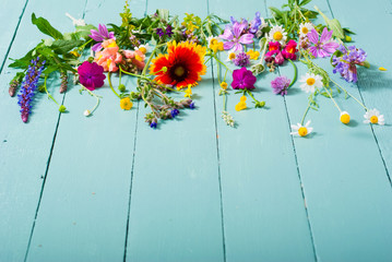 Wall Mural - herbal and wildflowers on blue wooden table background