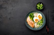 Asian ramen noodle soup with chicken on black concrete background. Top view, copy space for text