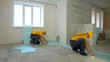 © DenisProduction.com - Builders working on the floor in new house. Workers laying insulation inside house.