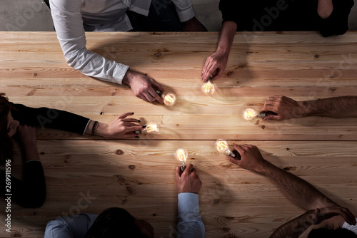 Cuadros en Lienzo Teamwork and brainstorming concept with businessmen that share an idea with a lamp