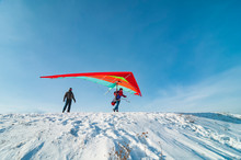 Hang Glider Pilot Ready To Take Off From Mountain Withhis Bright Wing.