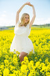 © JackF - Happy girl  stretch oneself  in rape seed flowers  field posing in white dress