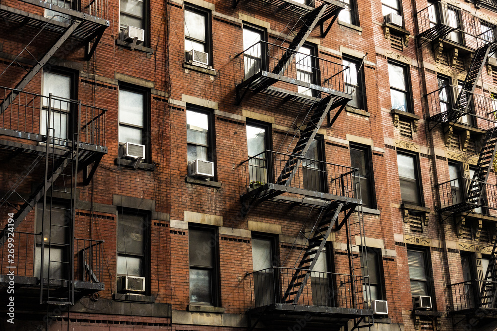 Close-up view of New York City style apartment buildings with emergency stairs along Mott Street in Chinatown neighborhood of Manhattan, New York, United States. - obrazy, fototapety, plakaty 