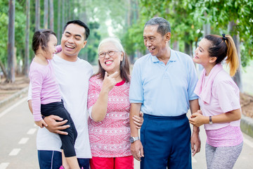 Poster - Little girl chats with her family in the park