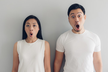 Surprised and shocked couple lover in white t-shirt and grey background.