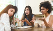 Upset multiethnic girls having an argument with third friend