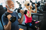 Mature fit couple exercising in gym to stay healthy