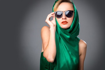 Wall Mural - Portrait of a beautiful sexy blonde in green dress, sunglasses and head scarf. Summer, spring fashion woman