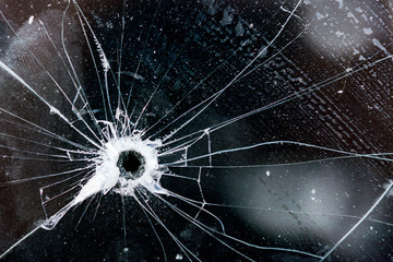 Bullet hole in glass, glass texture with cracks and scratches