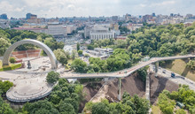 Aerial Drone View Of New Pedestrian Cycling Park Bridge Construction, Hills, Parks And Kyiv Cityscape From Above, City Of Kiev Skyline, Ukraine