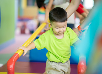 Wall Mural - Little toddler boy working out at the indoor gym excercise