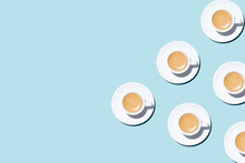 Pattern Made Of Cup Of Cappuccino On Blue Background. Trendy Minimal Styled Flat Lay Photography With Cups Of Coffee.