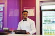 © AS Photo Family - African american bartender wear on bow tie using cash terminal screen at bar.