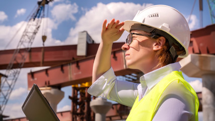 Wall Mural - female foreman inspects object at building site. Construction of central ring car road.