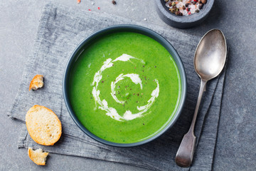 Wall Mural - Broccoli, spinach cream soup in a bowl with toasted bread. Top view. Plant based diet.