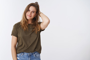Wall Mural - Attractive modern millennial good-looking charismatic european woman scratching head checking haircut tilting head silly cute smiling friendly camera standing relaxed casual white background