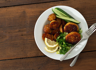 Wall Mural - Dinner plate with vegetarian food. Fresh vegetarian cutlets with new potatoes and salad on wooden table top view