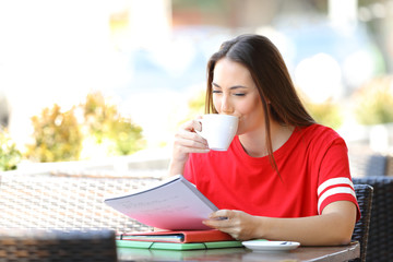 Student studying drinking coffee in a bar