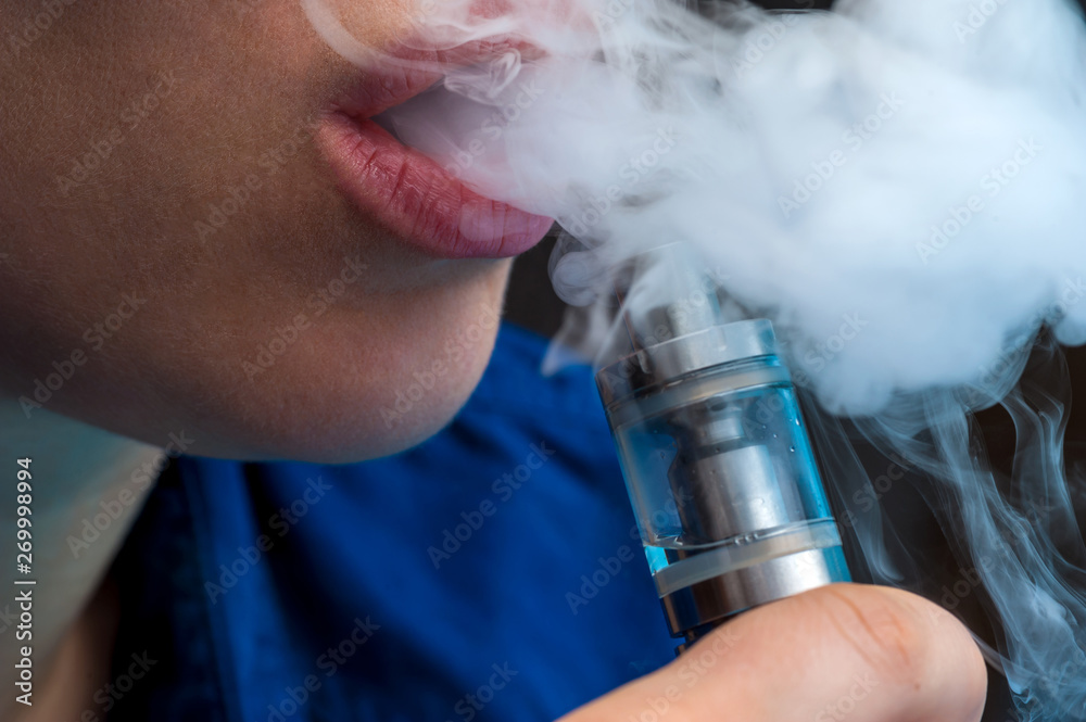 Close-up - young female vaping e-cigarette Stock Photo | Adobe Stock