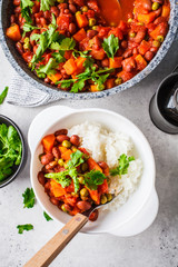 Wall Mural - Vegan bean stew with tomatoes and rice in a pan over white background.