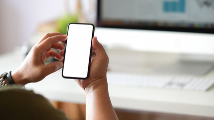 Cropped shot of man using smartphone in office