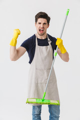 Wall Mural - Photo of handsome young man wearing yellow rubber gloves for hands protection holding mop while cleaning house