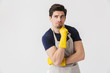 © Drobot Dean - Photo of attractive young man wearing yellow rubber gloves for hands protection posing at camera while cleaning house