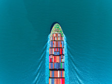 Aerial Top View Container Ship Full Speed With Beautiful Wave Pattern On The Blue Sea For Logistics, Import Export, Shipping Or Transportation.