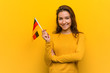© Asier - Young european woman holding a germany flag smiling confident with crossed arms.