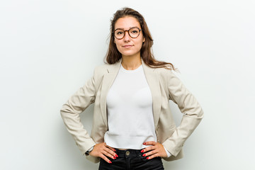 Young european business woman confident keeping hands on her hips.