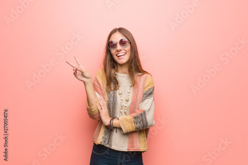 Fotografía Young hippie woman on pink background doing a gesture of victory