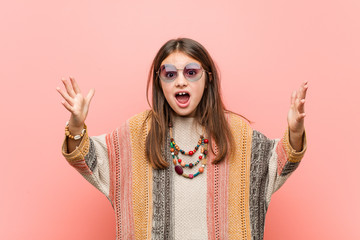 Wall Mural - Little hippie girl receiving a pleasant surprise, excited and raising hands.