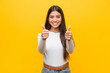 © Asier - Young pretty arab woman against a yellow background with thumbs ups, cheers about something, support and respect concept.