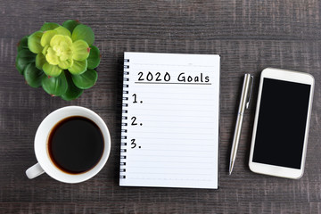 Wall Mural - New Year Resolution Concept - 2020 Goals text on note pad with smart phone on top on desk