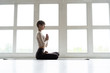 © opolja - Young attractive smiling woman practicing yoga, sitting in Half Lotus exercise, Ardha Padmasana pose, working out, wearing sportswear.