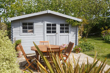 Shed With Terrace And Wooden Garden Furniture During Spring