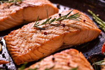 Wall Mural - Grilled salmon fish with various vegetables on pan on the flaming grill