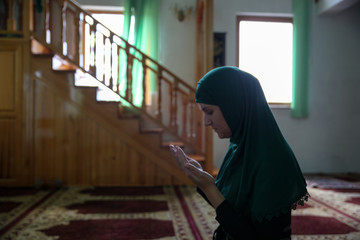 Wall Mural - Young Muslim woman praying,in the mosque