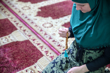 Wall Mural - Young Muslim woman praying,in the mosque