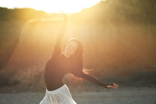 Ballet Woman Dancer At Sunset Beach. Classical Dance In White Chiffon Skirt