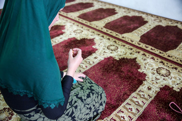 Wall Mural - Young Muslim woman praying in the mosque