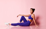 Fototapeta Panele - Sporty slim brunette fitness woman in blue sport wear after workout exercise full body on pink 