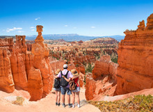 Family Standing Next To Thor's Hammer Hoodoo On Top Of  Mountain Looking At Beautiful View. Father With Arms Around His Family Enjoying Time Together. Bryce Canyon National Park, Utah, USA