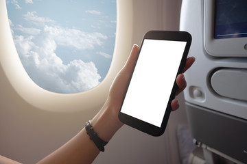 Wall Mural - Asian woman touching and slide mobile phone screen on airplane or aircraft,blank mobile phone screen mock up,selective focus