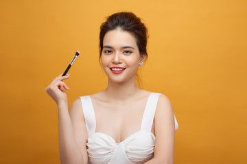 Woman applying make up with brush, isolated. Beauty procedures